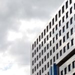 Innovative Materials - a tall building with many windows and a sky background