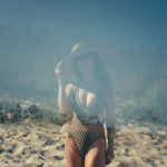 Weather Effects - a woman in a bathing suit standing on a sandy beach