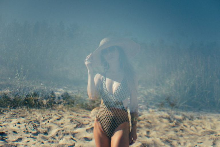 Weather Effects - a woman in a bathing suit standing on a sandy beach