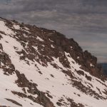 Extreme Conditions - a man riding skis down a snow covered slope