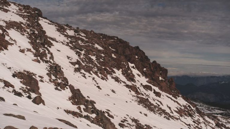 Extreme Conditions - a man riding skis down a snow covered slope
