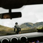 Driving Habits - a man riding a bike down a dirt road