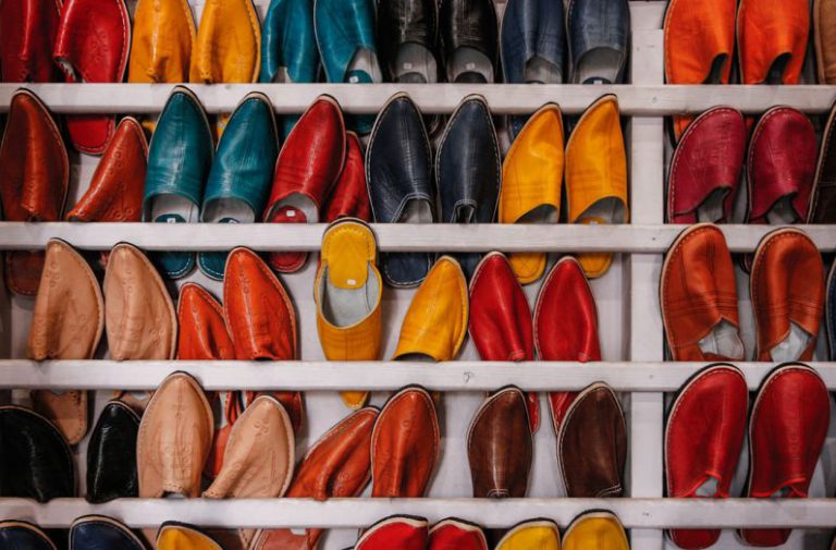 Demand Reduction - assorted-color shoe lot on white wooden shelf