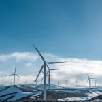 Energy Comparison - wind turbines on snowy mountain under clear blue sky during daytime