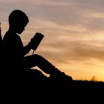 Environmental Education - silhouette of child sitting behind tree during sunset