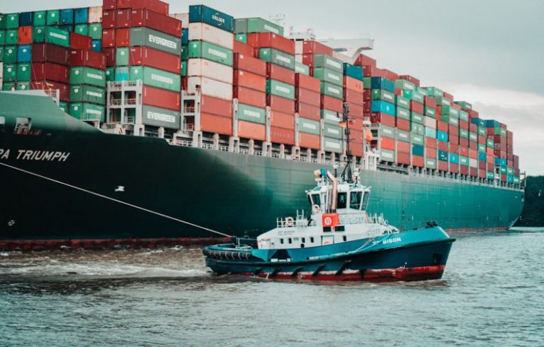 Supply Chain - a tug boat pulling a large container ship