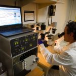 Cost Analysis - man looking at microscope