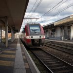 Sustainability Edge - a red and white train pulling into a train station